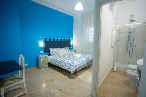 ein blaues Schlafzimmer mit einem Bett und einer Dusche in der Unterkunft B&B Antares in Reggio di Calabria