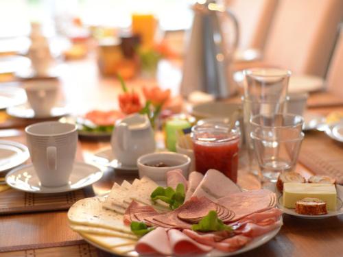 a wooden table with plates of food on it at Cyrano Vendégház in Vonyarcvashegy