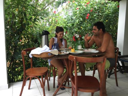 een man en een vrouw zitten aan een tafel bij Campos Elísios Boipeba in Ilha de Boipeba