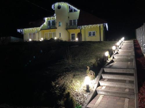 a house with lights on the side of a yard at night at Agata in Wisła