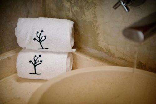 zwei Handtücher mit Bäumen auf der Toilette in der Unterkunft Ya'ax Hotel Boutique in Mérida