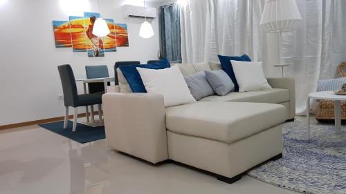 a living room with a white couch and a table at Elegant Modern Blue Apartment in Praia