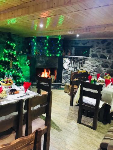 a dining room with a fireplace and a christmas tree at Hotel Elite House in Mestia