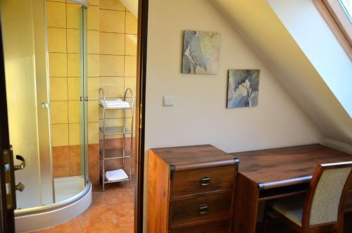 een badkamer met een douche en een houten bureau en een wastafel bij Zofijówka in Osjaków