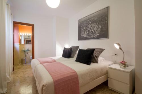 um quarto com uma cama e uma fotografia na parede em Apartamentos Turísticos Duque de Hornachuelos em Córdoba