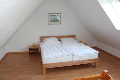 ein Schlafzimmer mit einem Bett im Dachgeschoss in der Unterkunft Ferienwohnungen Hensel in Minsen