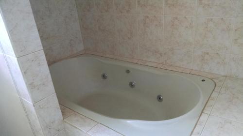 a bath tub in a bathroom with a tiled floor at Bekassin Botucatu Hotéis Ltda in Botucatu