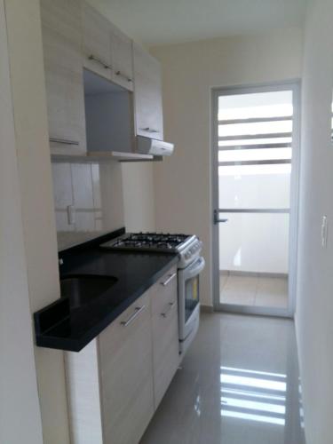 a kitchen with a stove and a sink in it at Departamento Acapulco Diamante in Acapulco