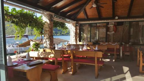 a restaurant with tables and chairs and a view of the water at Apartments Linda in Polače