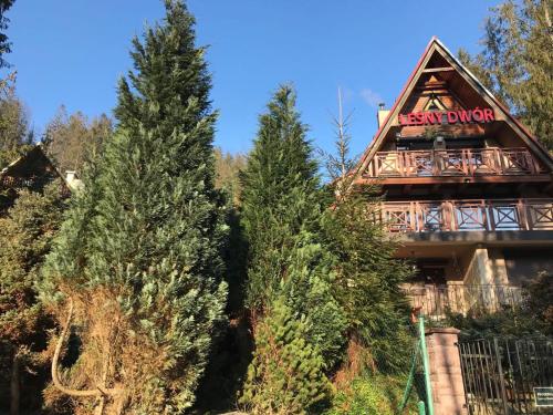 a building with trees in front of it at Leśny Dwór in Wisła