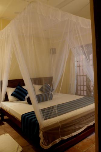 a bed with a canopy in a room at A4 Villa & Spa. in Habarana