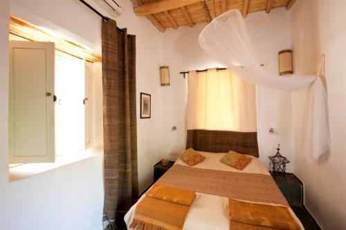 a bedroom with a bed and a window at Maison d'Hôtes Irocha in Tisselday