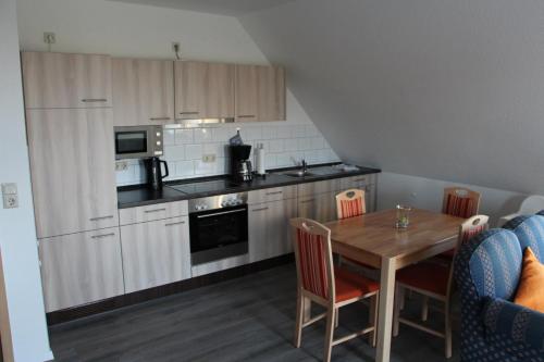 a kitchen with a wooden table and a table and chairs at Ferienwohnungen Hensel in Minsen
