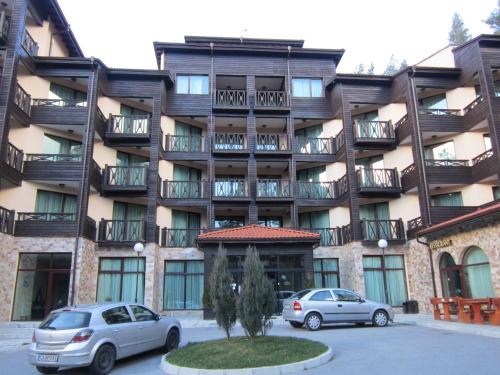 two cars parked in front of a building at Хотел Магнолия, Hotel Magnoliya in Panichishte