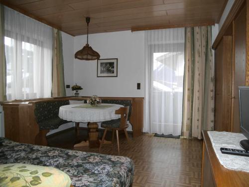 a living room with a table and a room with a bed at Apartments Jäger in Trins
