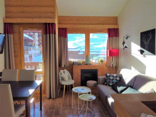 ein Wohnzimmer mit einem Sofa und einem Tisch in der Unterkunft Duplex skis aux pieds Belle Plagne in Belle Plagne