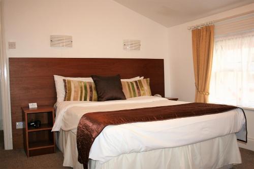 a bedroom with a large bed and a window at Ilfracombe House Hotel - near Cliffs Pavilion in Southend-on-Sea