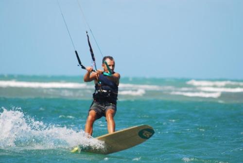 uma pessoa numa prancha de surf na água em Pousada Malea em Icaraí