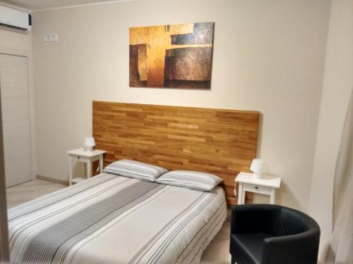 a bedroom with a bed and a chair at B&B Via Roma 15 in Acquaviva delle Fonti