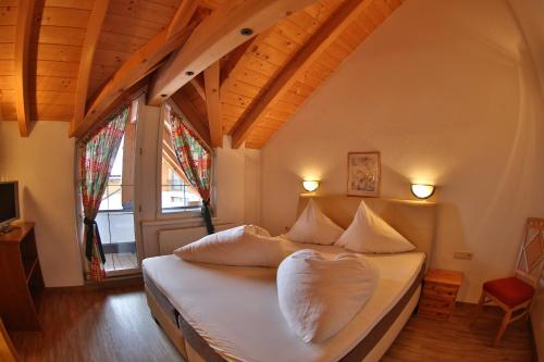 a bedroom with a bed with white sheets and pillows at Dependance Central in Ischgl