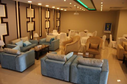 una sala de estar con sofás, mesas y sillas en Al Mokhmalia Residential Units, en Medina