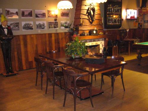 a man standing in a bar with a table and chairs at Hotel-Eetcafé d'Olde Heerd in Balkbrug