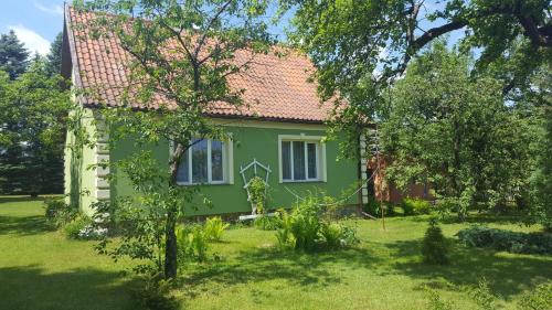 a green house with a red roof at Dom z kominkiem dla 12os. in Kruklanki