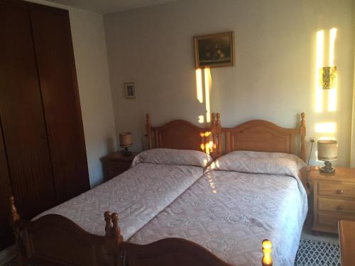 マラガにあるBeach Apartment Rosarioのベッドルーム1室(白いシーツを使用した大きな木製ベッド1台付)