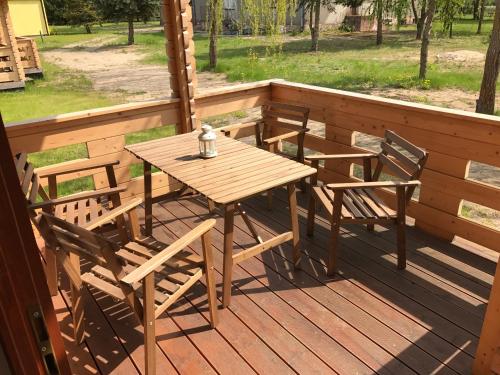 a wooden table and chairs sitting on a deck at Borowiak in Szteklin