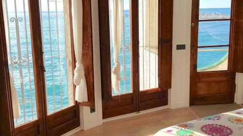 a bedroom with windows and a view of the ocean at Tot Gaviota in Sitges