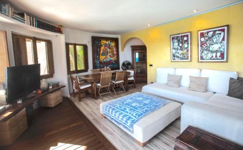 a living room with a white bed and a dining room at Tot Gaviota in Sitges