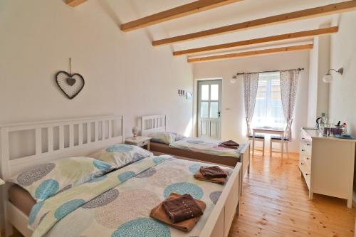 een slaapkamer met 2 bedden en een bureau in een kamer bij La Bobul Apartments in Dürnholz