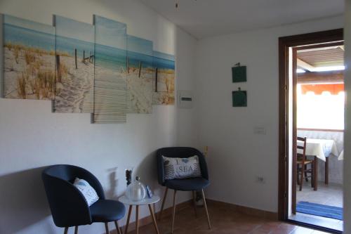 a dining room with two chairs and a painting on the wall at Locanda FarOrientale in Santa Lucia