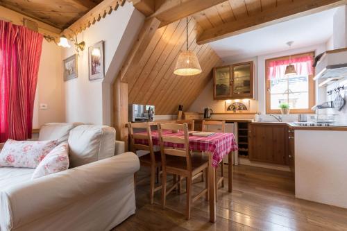 una cucina e un soggiorno con un tavolo e un divano di Bambi Cottage a Zakopane