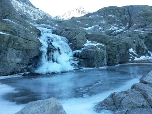 a waterfall in the mountains with snow at Artesano II in Navarredonda de Gredos