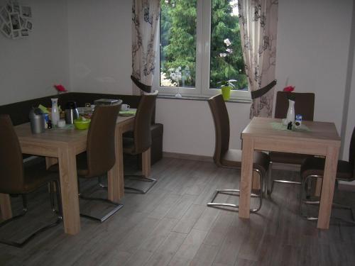 una sala da pranzo con due tavoli, sedie e una finestra di Spreewälder Ferienpension a Lübben