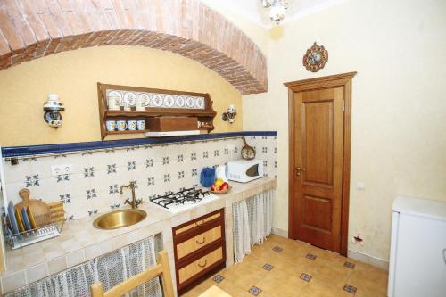 a small kitchen with a sink and a stove at Halytska in Lviv