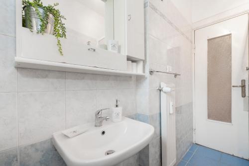 a white bathroom with a sink and a mirror at B&B Two Flowers in Rome