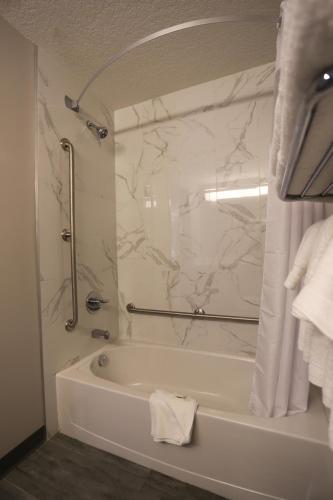a white bathroom with a tub and a shower at Days Inn by Wyndham Calgary North Balzac in Balzac