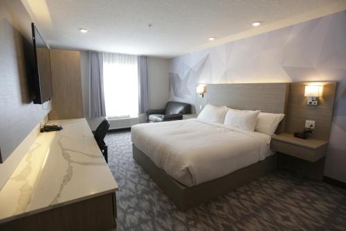 a hotel room with a bed and a desk at Days Inn by Wyndham Calgary North Balzac in Balzac