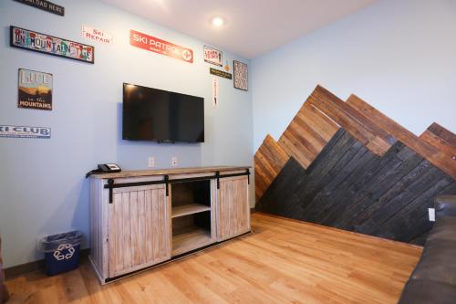 a room with a tv and a wooden wall at Days Inn by Wyndham Calgary North Balzac in Balzac