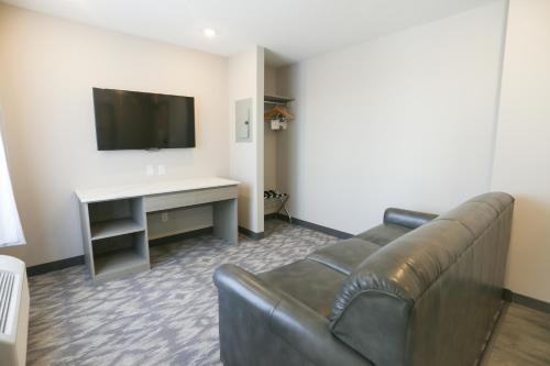 a living room with a couch and a television at Days Inn by Wyndham Calgary North Balzac in Balzac