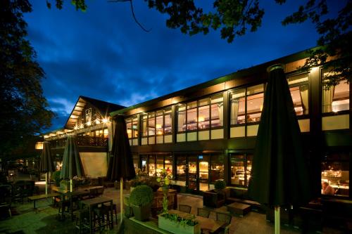 a building with tables and umbrellas in front of it at Van der Valk Hotel de Bilt-Utrecht in De Bilt
