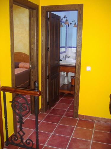 a yellow room with a bathroom with a sink at Casa El Pilpayu in poo de Llanes
