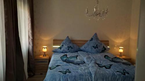 Schlafzimmer mit einem Bett mit blauer Bettwäsche und Kissen in der Unterkunft Ferienhaus Rosemarie in Breungeshain