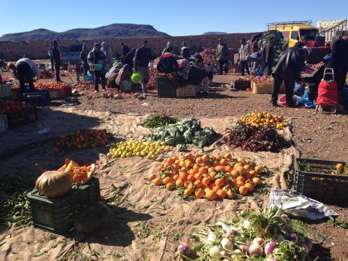 a group of people at a market with fruits and vegetables at Maison d'Hôtes Irocha in Tisselday