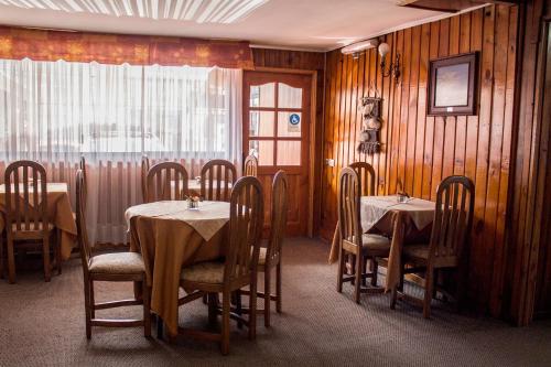 a dining room with tables and chairs and a window at Hotel Luanco in Temuco