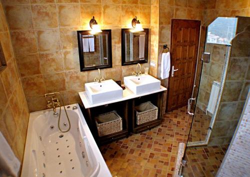 a bathroom with two sinks and a tub and a shower at Castle Cottage Bed & Breakfast in Belogradchik