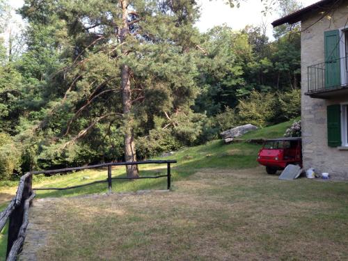 una recinzione di fronte a una casa con un albero di Baita Mirella a Torno