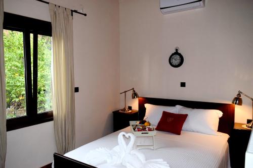 um quarto com uma cama e um relógio na parede em Villa Portreto em Kambanós